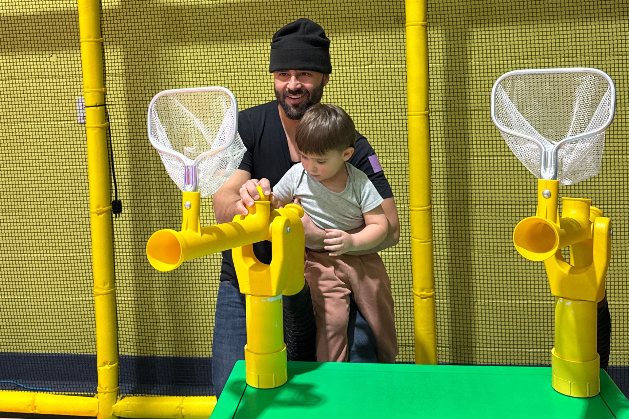 Father and Toddler taking shots on mini ball hoops