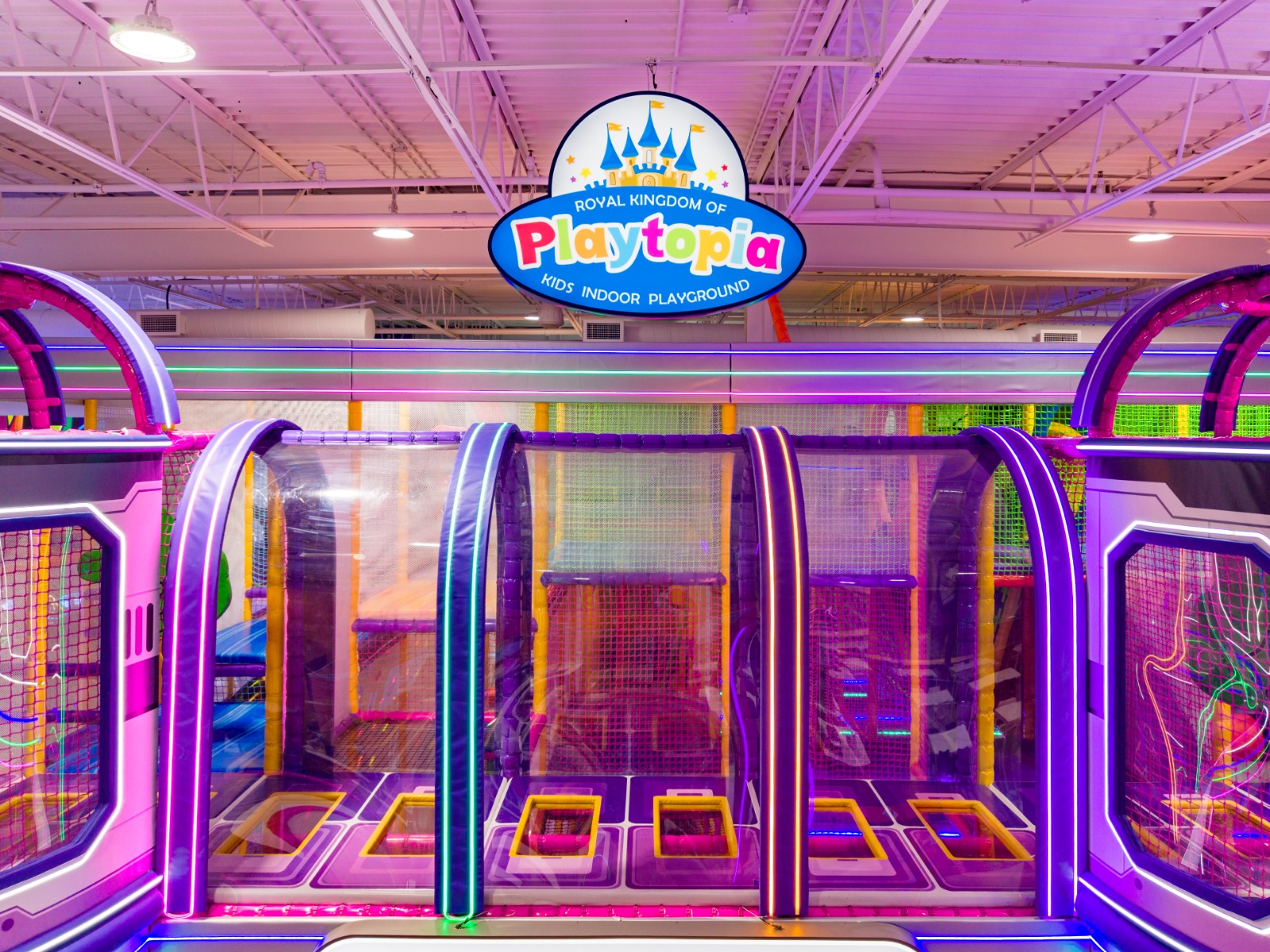 Padded indoor play structure entrance with Playtopia logo.