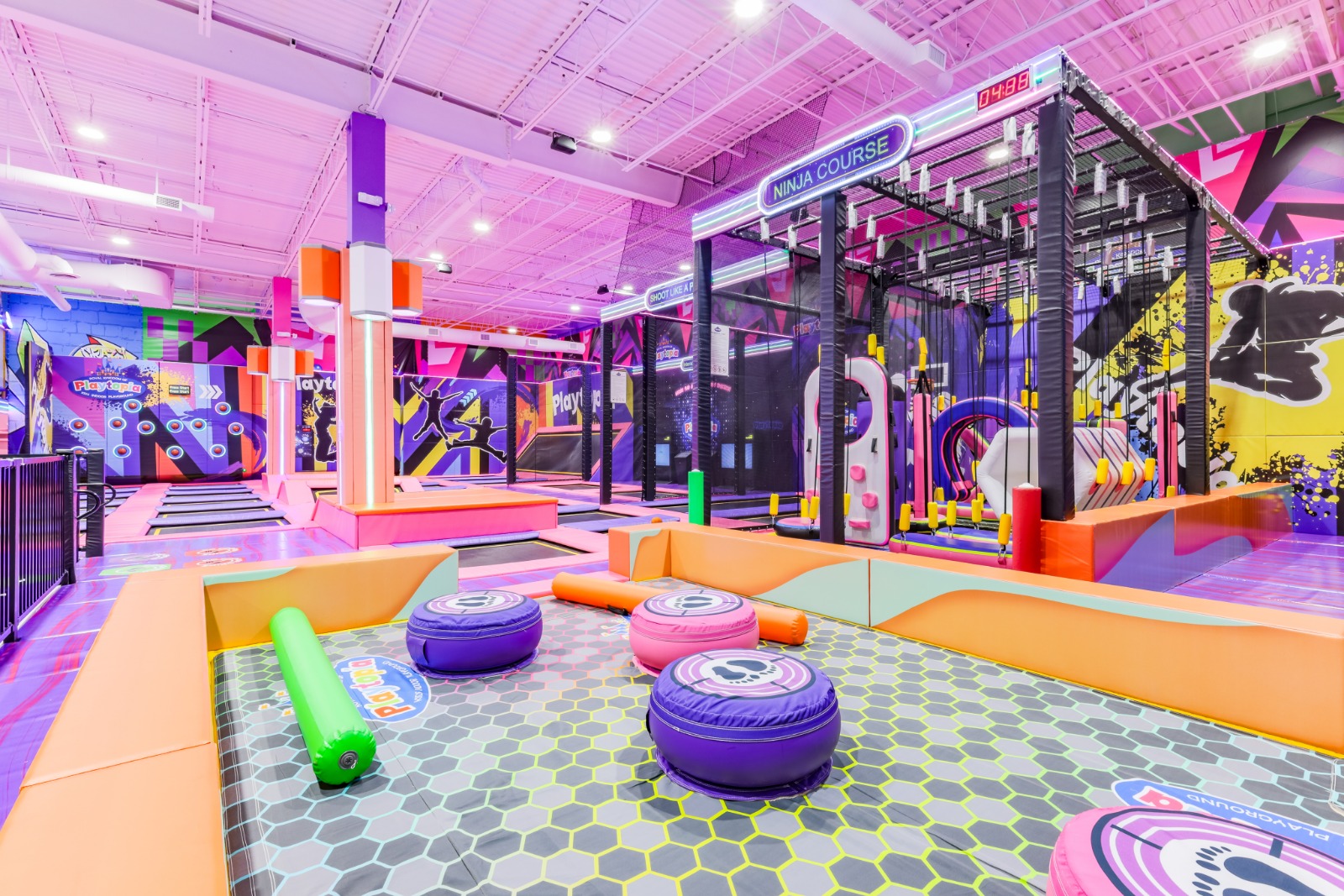 Indoor battle beam over a padded foam pit for kids.
