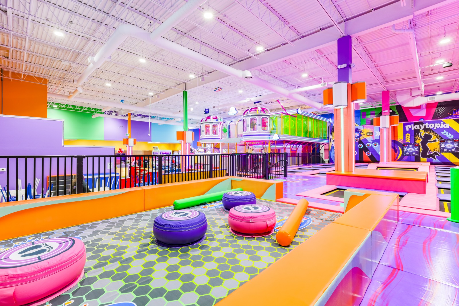 Wide view of Battle Beam arena with colorful foam pits.
