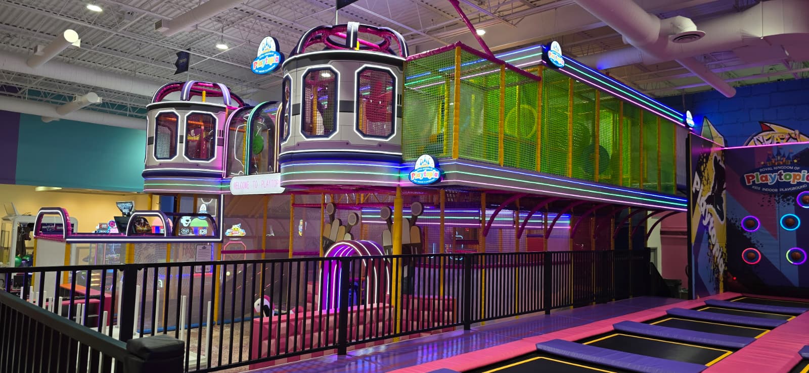 Multi-level indoor playground with neon purple lights.