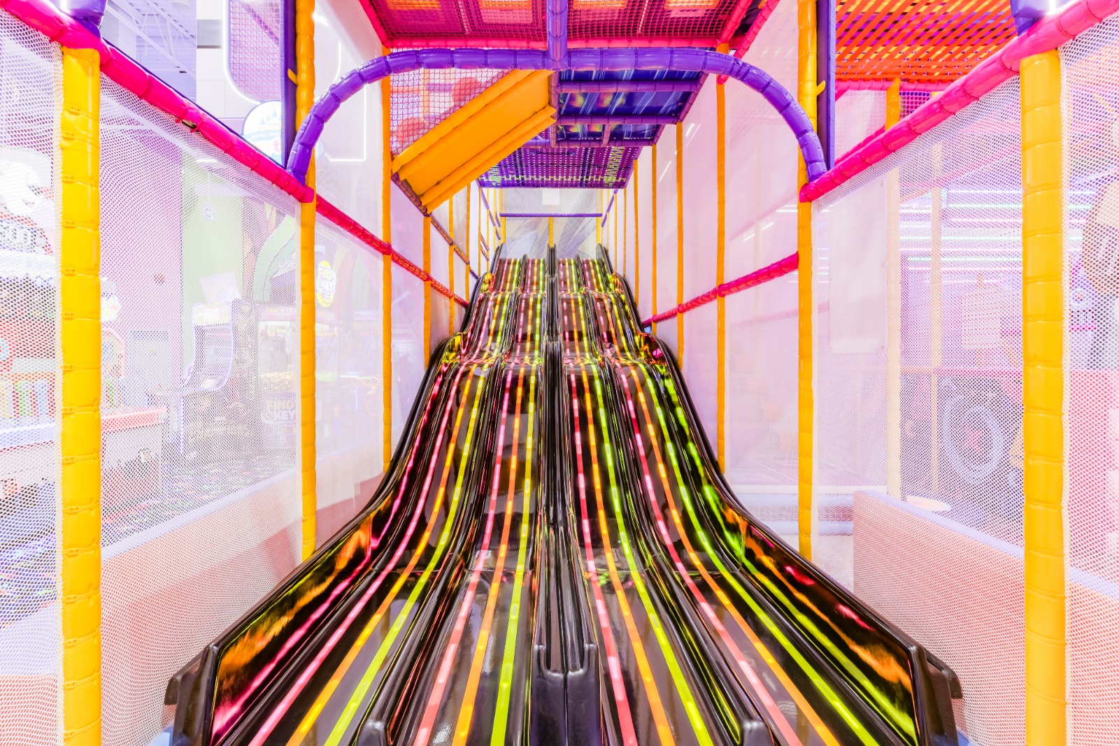 Multi-lane racing slide with neon glowing strips.