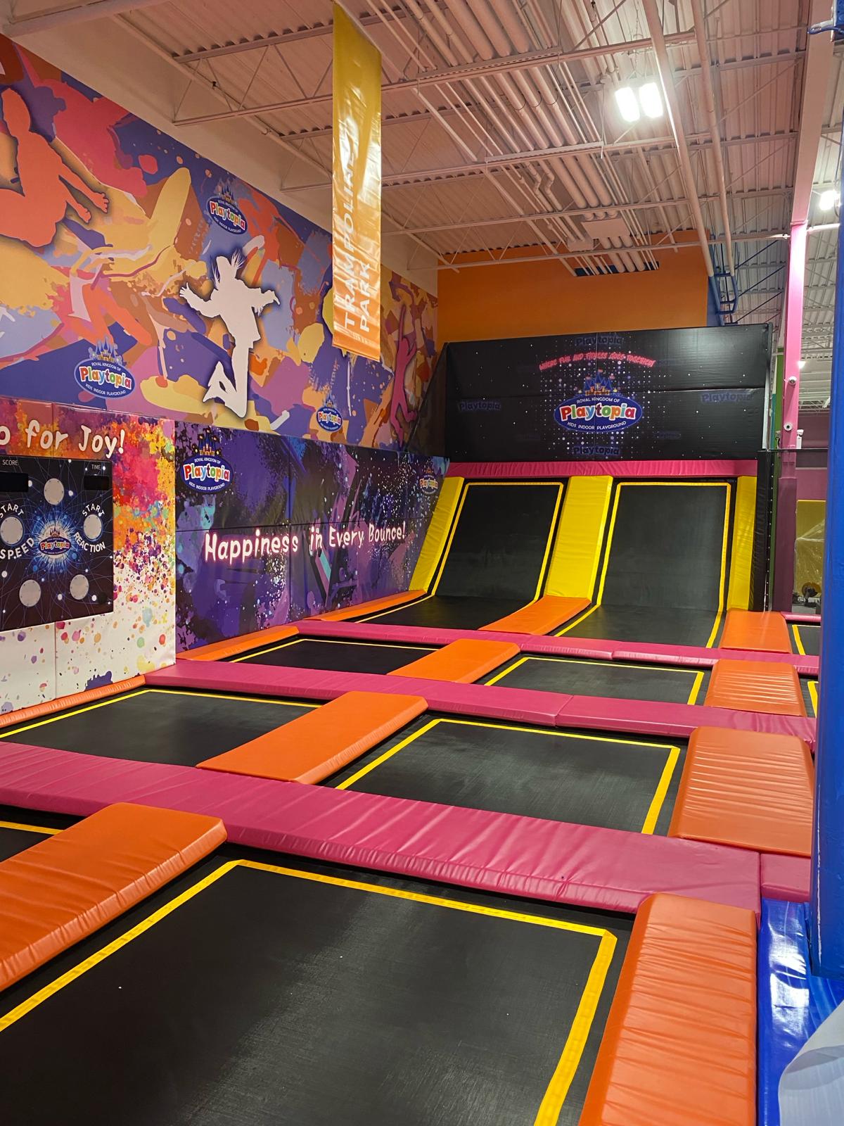 Parallel trampoline lanes with vibrant graffiti wall art.