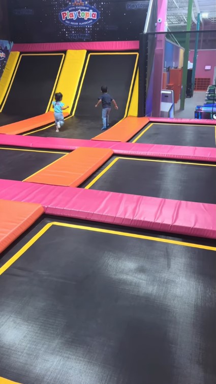 Parallel trampoline lanes with vibrant graffiti wall art.